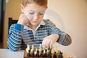 Little clever boy thinking with chess