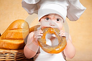 Little cook with a bagel in her hands