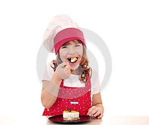 Little cook girl eat cake
