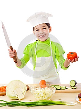 Little cook with knife and tomatoes