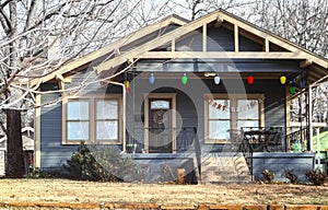 Little cottage with giant Christmas lights on porch and Merry Christmas acros window on bleak winter day photo