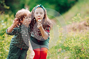 Little couple on Valentines Day. Enjoy Nature. Cute kids blowing dandelion. Kids walking in summer field.