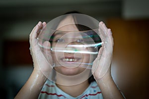 Little creative kid having fun with soap bubble during lockdown