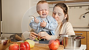 Little crying baby boy is upset becuase of food mother is giving to him. Concept of healthy nutrition,diet and children