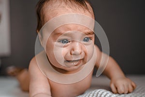 Little crying baby daughter on bed. One month age. Newborn cute happy beautiful girl smiling. Breast-feeding. Happiness