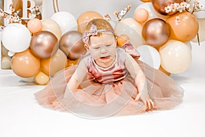 Little crying unhappy redhead baby girl celebrates first birthday anniversary. 1 year family party Professional