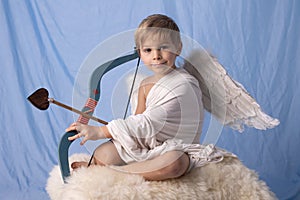 Little cupid toddle boy, holding bow and arrow, beautiful blond cherub