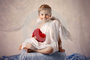 Little cupid toddle boy, holding bow and arrow, beautiful blond cherub