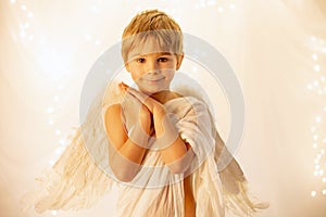 Little cupid toddle boy, holding bow and arrow, beautiful blond cherub photo