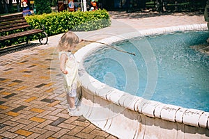 Little curly blonde girl playing outdoors.