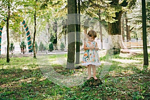 Little curly blonde girl playing outdoors.