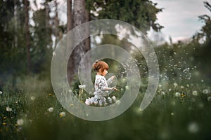 Little curly girl blowing dandelion