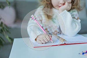 Little curly-haired cute blue-eyed girl 4 years old in a cozy house. Portrait of a happy child