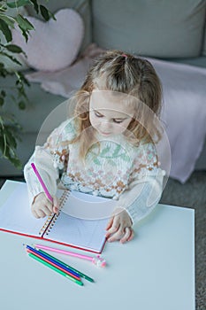 Little curly-haired cute blue-eyed girl 4 years old in a cozy house. Portrait of a happy child