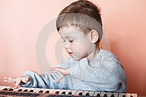 Little Cut Boy playing the digital piano. Happy childhood and music.