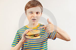 Little cut boy recommends tasty hamburger on white background