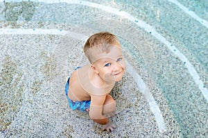 Little cute adorable blond playful beautiful caucasian active toodler boy enjoy playing at pool edge at summertime