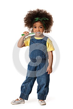 A little cute african american girl brushing her teeth, isolated