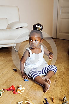 Little cute african american girl playing with animal toys at home, pretty adorable princess in interior happy smiling