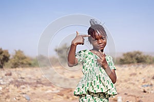 Little and cute African girl posing for the camera with hand gestures