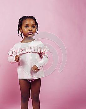 Little cute african girl posing cheerful inocent on pink background, lifestyle people concept