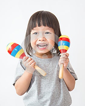 Little cute asian girl playing the maracas