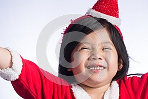 A Little Cute Asian girl in Santa Cross dress on white background.