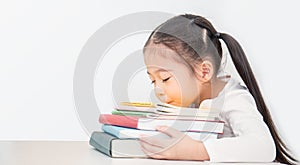 Little cute asian girl sleep on stack of books tried from school.