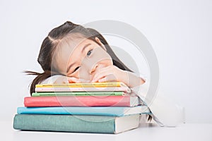 Little cute asian girl thinkig with stack of books ready to school.