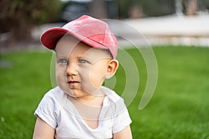 Little cute baby boy sitting on green grass on sunny day horizontal picture