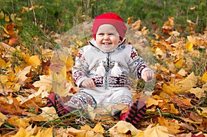 Little cute baby girl on a background of autumn leaves