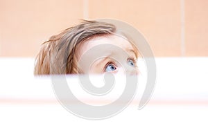 Little cute baby peeking out of the bath.