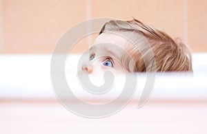 Little cute baby peeking out of the bath.