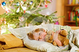 Little cute blond child sleeping under Christmas tree