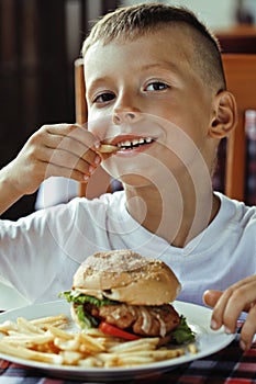 Little cute boy 6 years old with hamburger and