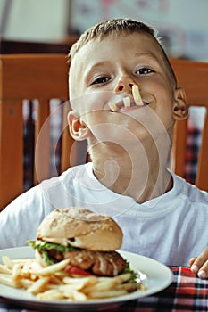 Little cute boy 6 years old with hamburger and
