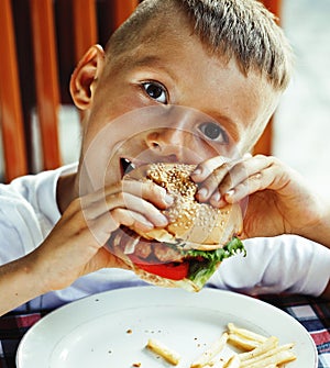 little cute boy 6 years old with hamburger and french fries maki