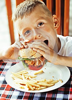 little cute boy 6 years old with hamburger and french fries maki