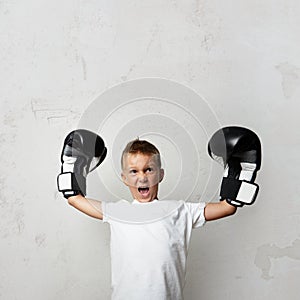 Little cute boy with boxing gloves celebrating his