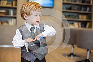 Little cute boy in business clothes with a puncher photo
