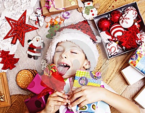 Little cute boy with Christmas gifts at home. close up emotional happy smiling in mess with toys, lifestyle holiday real