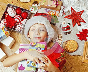 Little cute boy with Christmas gifts at home. close up emotional happy smiling in mess with toys, lifestyle holiday
