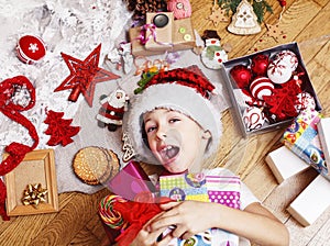 Little cute boy with Christmas gifts at home. close up emotional happy smiling in mess with toys, lifestyle holiday real