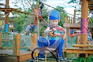 Little cute boy enjoying activity in a climbing adventure park o