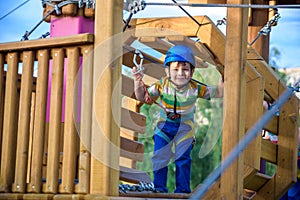 Little cute boy enjoying activity in a climbing adventure park o