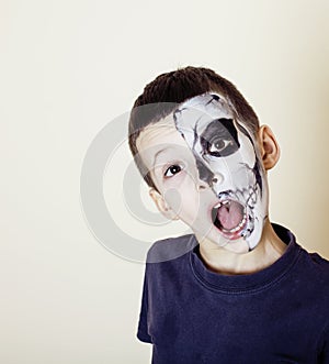 Little cute boy with facepaint like skeleton to celebrate halloween