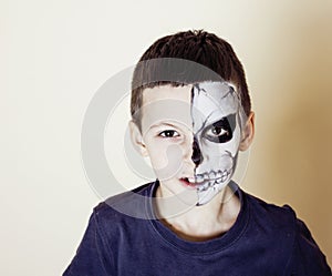 Little cute boy with facepaint like skeleton to celebrate halloween