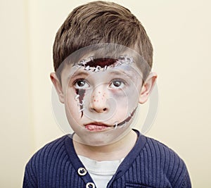 Little cute boy with facepaint like zombie apocalypse at halloween party close up