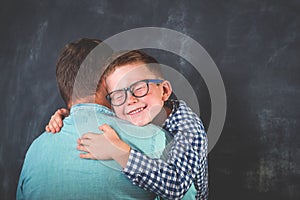 Little cute boy in glasses hug his dad. Son giving father cuddle. Happy family time. Love.