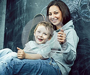 Little cute boy in glasses with young real teacher, classroom studying, lifestyle people concept